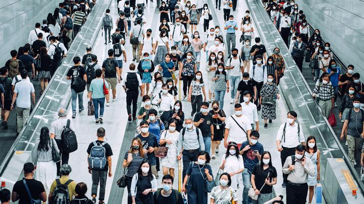 Crowd of commuters wearing masks